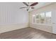 Bedroom with wood floors, ceiling fan, window with shutters, and geometric wall at 2404 Garganey Ave, North Las Vegas, NV 89084