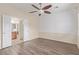 Bedroom with wood floors, ceiling fan, geometric wall, and doors to the bathroom at 2404 Garganey Ave, North Las Vegas, NV 89084