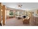 Cozy living room with large windows, neutral carpet, ceiling fan and comfortable seating at 2467 Moonlight Valley Ave, Henderson, NV 89044