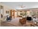 Spacious living room with a ceiling fan, large windows, and comfortable wicker seating at 2467 Moonlight Valley Ave, Henderson, NV 89044