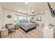 Bedroom with bay window, ceiling fan, light wood floors, and comfortable armchair by the window at 2825 E Hacienda Ave, Las Vegas, NV 89120