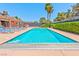 Serene community pool area featuring lounge chairs, mature trees, and clear blue water at 2825 E Hacienda Ave, Las Vegas, NV 89120