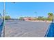 Wide shot of an outdoor tennis court with lighting, adjacent to other community amenities at 2825 E Hacienda Ave, Las Vegas, NV 89120