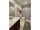 Well-maintained bathroom featuring a shower with floral curtains, tile flooring, and a neutral color scheme at 2829 Mozia Ct, Henderson, NV 89044