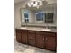 Stylish bathroom featuring a double vanity with granite countertops, dark wood cabinets, and a large framed mirror at 2829 Mozia Ct, Henderson, NV 89044