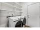 Laundry room with Samsung washer and dryer, built-in white shelving and rod for hanging at 2894 Via Firenze, Henderson, NV 89044