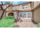 Townhome exterior showcases a stone archway, tiled roof, and manicured shrubbery, complemented by a brick pathway at 3064 Bicentennial Pkwy, Henderson, NV 89044