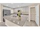 Kitchen island featuring a granite countertop, stainless steel sink, white cabinetry, and stainless steel appliances at 3064 Bicentennial Pkwy, Henderson, NV 89044