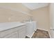 Bright laundry room featuring white washer and dryer units, storage cabinets, and tile flooring at 3064 Bicentennial Pkwy, Henderson, NV 89044