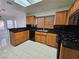 Kitchen featuring black countertops, tile flooring, and wooden cabinetry at 3104 Archwood Way, Las Vegas, NV 89134