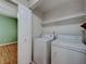 A laundry room with washer and dryer units and a partial view of an adjacent room at 312 Manti Pl, Henderson, NV 89014