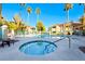 Community pool area featuring palm trees, jacuzzi and lounge seating in a fenced enclosure at 312 Manti Pl, Henderson, NV 89014