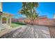 This backyard features a beautiful brick fence and a covered patio area at 3705 Covewick Dr, North Las Vegas, NV 89032