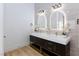 Modern bathroom featuring a double sink vanity, gold hardware and decorative flowers at 3957 Genoa Dr, Las Vegas, NV 89141