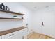 Bright laundry room featuring built-in storage cabinets and floating shelves at 3957 Genoa Dr, Las Vegas, NV 89141