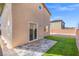 Outdoor space with artificial grass, stone patio, sliding glass door, and privacy fencing at 430 Shimmering Sands Ave, North Las Vegas, NV 89031