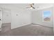 Bright bedroom with plush carpet, a ceiling fan and a window overlooking the neighborhood at 430 Shimmering Sands Ave, North Las Vegas, NV 89031