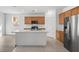 Bright kitchen features an island, stainless appliances and wood cabinets at 430 Shimmering Sands Ave, North Las Vegas, NV 89031