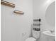 Contemporary half bathroom featuring a pedestal sink, modern fixtures, and decorative shelving at 430 Shimmering Sands Ave, North Las Vegas, NV 89031