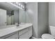 Bathroom featuring a white vanity, large mirror, updated lighting, gray walls and white trim at 4421 Rodman Dr, Las Vegas, NV 89130