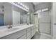 Bright bathroom featuring a double sink vanity with white cabinets and a glass-enclosed shower at 4421 Rodman Dr, Las Vegas, NV 89130