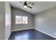 Bedroom featuring a ceiling fan, gray walls, dark wood-look floors, and a large window at 4421 Rodman Dr, Las Vegas, NV 89130