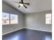 Bedroom featuring a ceiling fan, gray walls, dark wood-look floors, and two windows at 4421 Rodman Dr, Las Vegas, NV 89130