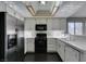 Bright kitchen featuring stainless steel refrigerator, black oven, white cabinets, and dark wood-look flooring at 4421 Rodman Dr, Las Vegas, NV 89130