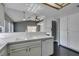 Bright open concept featuring white tile countertops, white cabinets, dishwasher, and dark wood-look flooring at 4421 Rodman Dr, Las Vegas, NV 89130