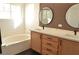 Beautiful bathroom featuring dual sinks, modern light fixture, and decorative mirrors with a view of the tub at 4473 Oberlander Ave, North Las Vegas, NV 89031