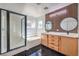 Modern bathroom featuring dual sinks, stylish wood accent wall, separate shower and bathtub at 4473 Oberlander Ave, North Las Vegas, NV 89031