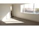 Bedroom with neutral carpeting, trim and a large window, with a doorway leading to another room at 4473 Oberlander Ave, North Las Vegas, NV 89031