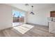 Bright dining area with wood-look flooring, modern light fixture, and sliding glass doors leading to the backyard at 4473 Oberlander Ave, North Las Vegas, NV 89031