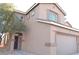 Exterior front view of the home featuring desert landscaping, a garage, and a covered porch at 4473 Oberlander Ave, North Las Vegas, NV 89031