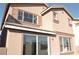 Exterior view of the back of the home with windows and a sliding glass door at 4473 Oberlander Ave, North Las Vegas, NV 89031