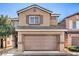 Inviting two-story home featuring an attached two-car garage and neutral stucco exterior, creating a warm curb appeal at 4473 Oberlander Ave, North Las Vegas, NV 89031