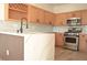 This kitchen features wooden cabinets, stainless steel appliances, quartz countertops, and a wine rack at 4473 Oberlander Ave, North Las Vegas, NV 89031