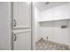 This laundry room has custom tile, white cabinets, shelving and W/D hookups at 4473 Oberlander Ave, North Las Vegas, NV 89031