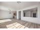 Open-concept living area featuring wood-look floors, modern lighting, and a peek-through to the adjacent kitchen area at 4473 Oberlander Ave, North Las Vegas, NV 89031