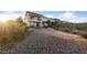 Expansive gravel backyard featuring a patio set and a view of the two-story home with balcony at 4504 Eagle Nest Peak St, Las Vegas, NV 89129