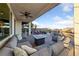 Backyard patio features a gray sectional, ceiling fan, a fire pit, and a view of the surrounding desert at 4504 Eagle Nest Peak St, Las Vegas, NV 89129