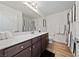 Bathroom with a wood floor, dark cabinets, white counter and black and white striped shower curtain at 4504 Eagle Nest Peak St, Las Vegas, NV 89129