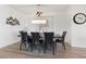 Open dining room area with a dark wood table, black leather chairs, and a modern light fixture at 4504 Eagle Nest Peak St, Las Vegas, NV 89129