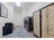 Laundry room with stackable washer and dryer, cabinet, door to outside, desk and colorful cabinet at 4504 Eagle Nest Peak St, Las Vegas, NV 89129