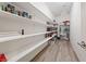 Pantry with white shelving, chandelier, and wood-look laminate flooring at 4504 Eagle Nest Peak St, Las Vegas, NV 89129