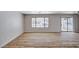 Bright living room featuring wood floors, a sliding glass door, and a large window with a view of the backyard at 4839 Englewood Ave, Las Vegas, NV 89139