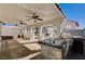 Spacious covered patio with outdoor kitchen, including stainless steel sink and built-in grill under ceiling fans at 4839 Englewood Ave, Las Vegas, NV 89139