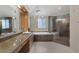 A spacious bathroom featuring double sinks, a walk-in shower, and a bathtub under a chandelier at 4925 Turtle Point Dr, Las Vegas, NV 89113