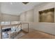 Spacious hallway with wood floors, wood railing, and a view of the living room with a fireplace at 4925 Turtle Point Dr, Las Vegas, NV 89113