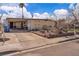 Single-story home with a large, paved driveway, desert landscaping, and unique architectural details at 5125 Hallet Dr, Las Vegas, NV 89122